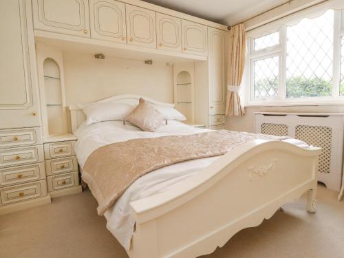 a white bedroom with a large bed and a window at 23 Wolsey Close in Thornton