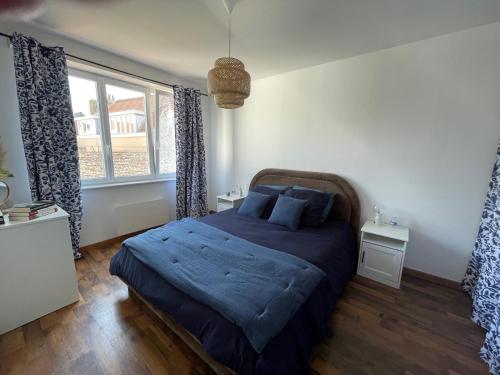 ダンケルクにあるGoldfinger- appartement Malo-les-Bainsのベッドルーム1室(青いシーツと窓付)