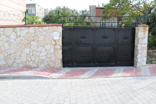 una porta nera del garage con un muro di pietra di Gallipoli Dublex House a Çanakkale