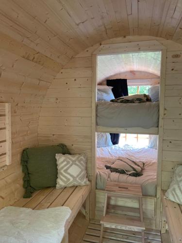 two bunk beds in a wooden cabin with a window at Le Hameau in Florent-en-Argonne