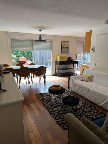 un salon avec un lit, une table et des chaises dans l'établissement LODGE CAP, à Lège-Cap-Ferret