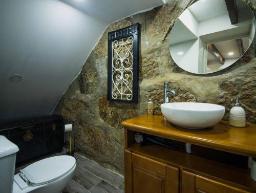 een badkamer met een wastafel en een spiegel bij Casa das Vigas I in São Mamede de Infesta