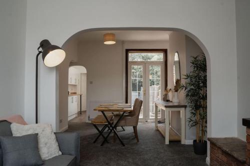 a living room with a table and a dining room at Valley Park House - By Sigma Stays in Crewe