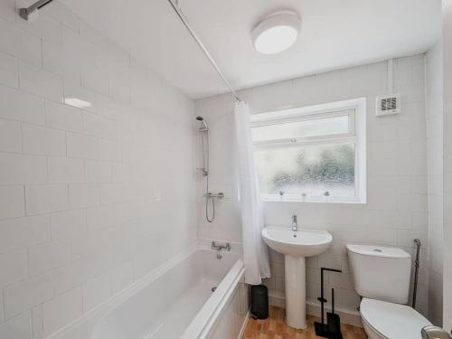 baño con lavabo y aseo y ventana en Valley Park House - By Sigma Stays, en Crewe