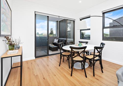 a living room with a dining room table and chairs at Sea Dreams in Gerringong