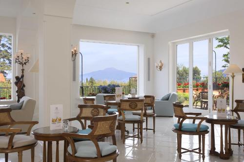 a restaurant with tables and chairs and a large window at Grand Hotel de la Ville in Sorrento