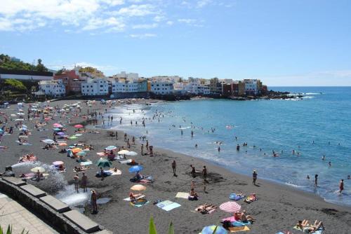 a group of people on a beach in the water at San Felipe Suites in Puerto de la Cruz