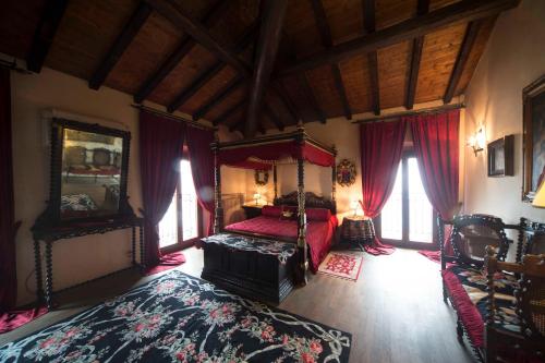 - une chambre avec un lit à baldaquin rouge dans l'établissement Hotel Castello Di Vigoleno, à Vigoleno
