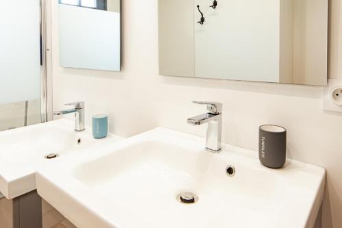 a white bathroom with two sinks and a mirror at Jolie m'Home, Le Puy du Fou, 15 pers, 7 ch, 5 sde, 5 wc in Mauléon