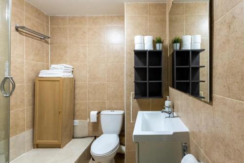 a bathroom with a toilet and a sink at Camden Apartment By Morethanstays in London