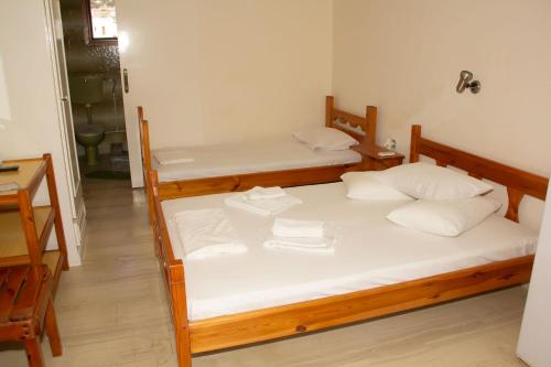 two beds in a room with white sheets and pillows at Aristidis in Galissas