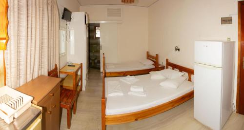 a small room with two beds and a refrigerator at Aristidis in Galissas