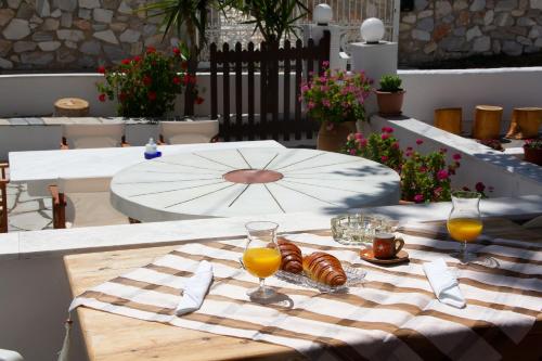 stół z kieliszkami soku pomarańczowego i jedzeniem na nim w obiekcie Aristidis w mieście Galissas