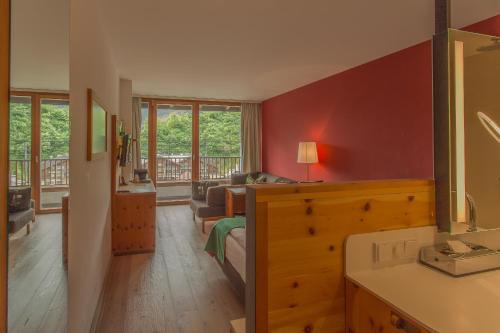 a bedroom with a bed and a living room at SPA Hotel Erzherzog Johann in Bad Aussee