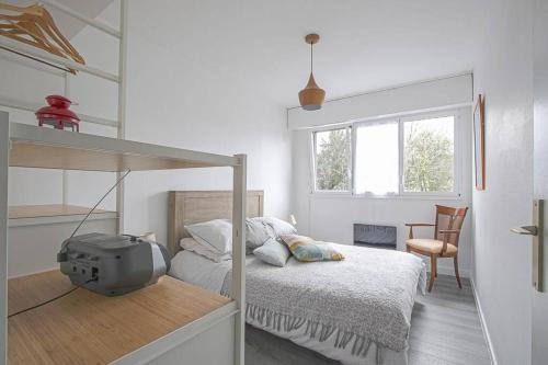 une chambre blanche avec un lit et une fenêtre dans l'établissement Appt agréable avec balcon au sud-ouest de Caen, à Caen