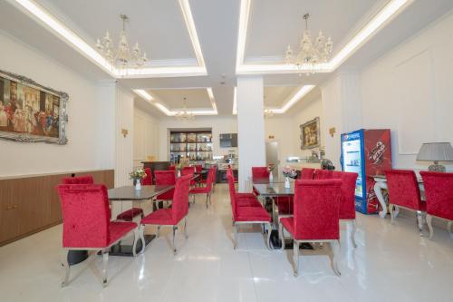 a dining room with red chairs and a table at A25 Hotel - 255 Lê Thánh Tôn in Ho Chi Minh City