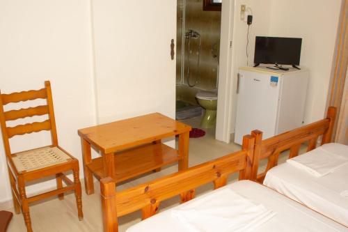 a room with a table and a chair and a television at Aristidis in Galissas