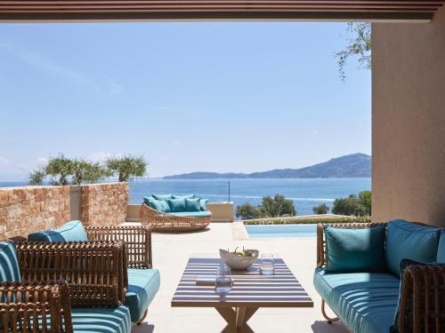 a patio with furniture and a view of the ocean at MarBella, Mar-Bella Collection in Agios Ioannis Peristeron