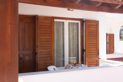 a room with wooden doors and a table and a window at Aristidis in Galissas