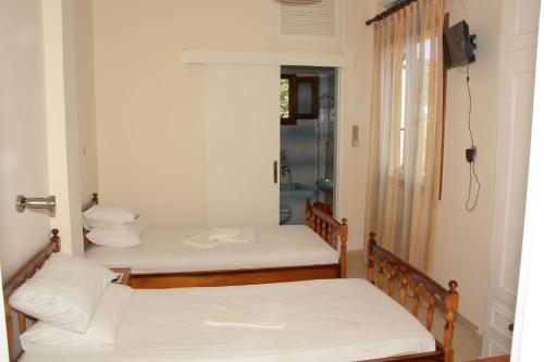 two beds in a room with a mirror at Aristidis in Galissas