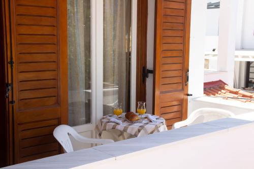 a table with two glasses of orange juice on a porch at Aristidis in Galissas