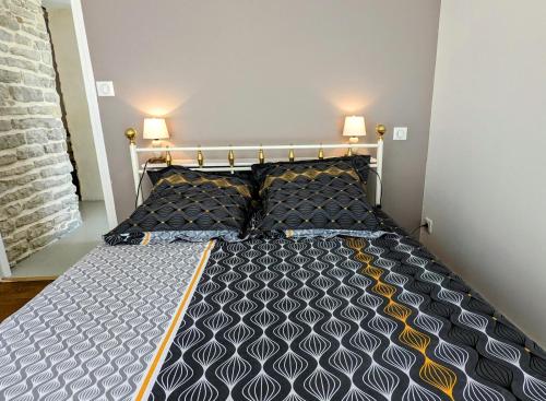 a bed in a bedroom with two lamps on the wall at Le Cocon et le panorama des Hautes-Côtes in Fussey