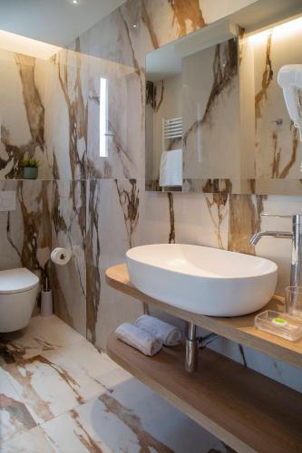 a bathroom with a white sink and a toilet at Hotel Mon Cheri in Riccione
