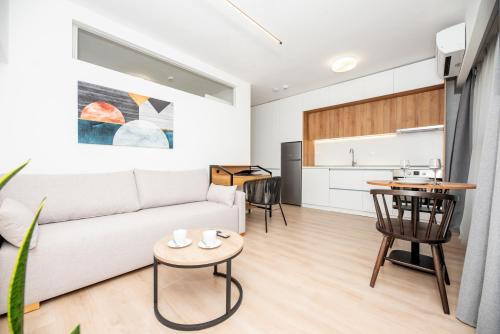 un soggiorno con divano bianco e tavolo di LASARI comfort living a Salonicco