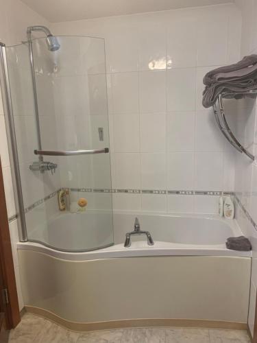 a white bath tub with a glass shower door at Ruthven in Stevenston