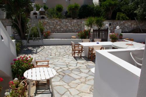 a patio with tables and chairs and a stone floor at Aristidis in Galissas