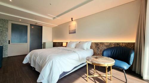 Habitación de hotel con cama, mesa y silla en Hotel GITE en Siheung