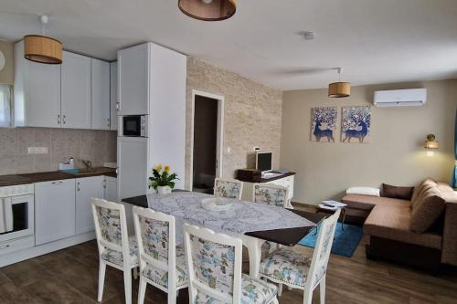 a kitchen and living room with a table and chairs at Borostyánkút Wellness Home Bakonybél in Bakonybél