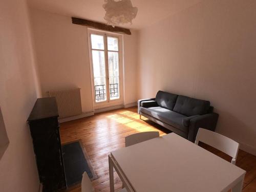 uma sala de estar com um sofá e uma mesa em Rochereau de la Clautre em Périgueux