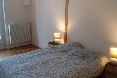 um quarto com uma cama e 2 candeeiros em mesas de cabeceira em Rochereau de la Clautre em Périgueux