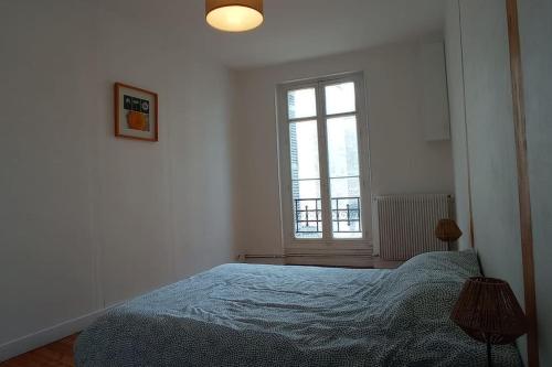 een witte slaapkamer met een bed en een raam bij Rochereau de la Clautre in Périgueux