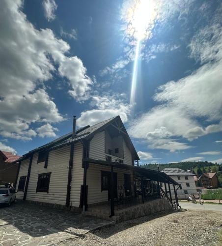 a white building with the sun in the sky at Palaga Bukovel in Bukovel