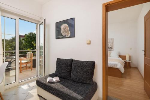 a room with a couch and a bed and a balcony at Apartments Tihi III in Vodice