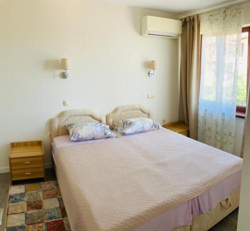 a bedroom with a bed with two pillows on it at Splandid apartment by the sea in Sozopol