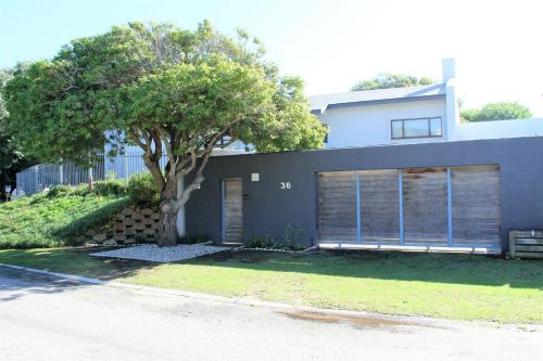 a house with a tree in front of it at 36 @ Plett! in Plettenberg Bay