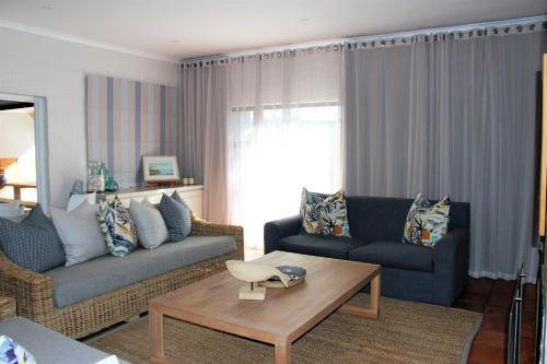 a living room with two couches and a coffee table at 36 @ Plett! in Plettenberg Bay