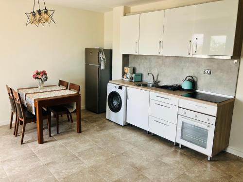 a kitchen with a table and a sink and a refrigerator at Splandid apartment by the sea in Sozopol