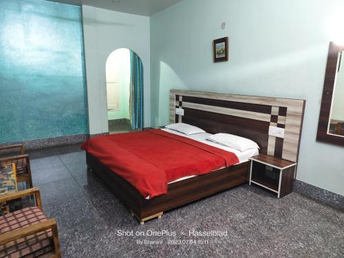 a bedroom with a bed with a red blanket at Hotel Swapna in Vānivilāsa Puram