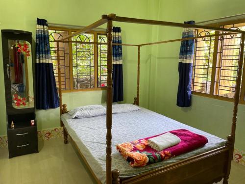 um quarto com uma cama de madeira com uma estrutura de madeira em Vamoose S Das Homestay em Agartala