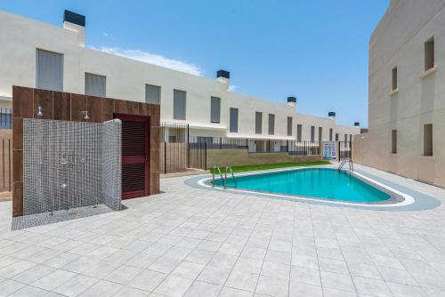 una piscina nel cortile di un edificio di MEDANO4YOU La Jaquita Terrace Holiday Home a El Médano