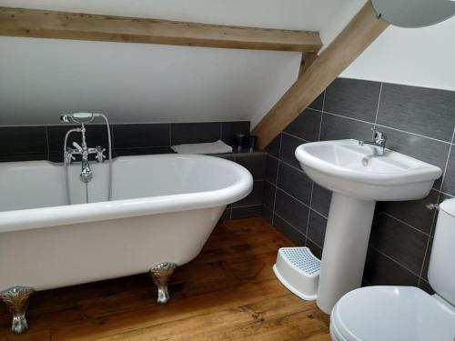 une salle de bain avec une baignoire, un lavabo et des toilettes dans l'établissement Bonne Chere, Family Friendly Cottage with Pool LPS, à Malguénac