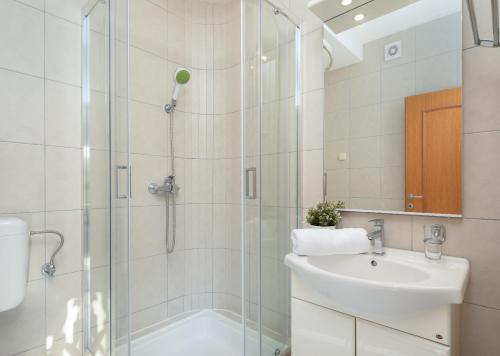 une salle de bain avec douche et lavabo dans l'établissement Apartments Tihi III, à Vodice