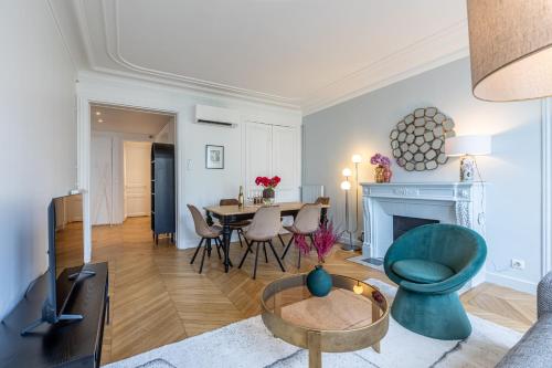 uma sala de estar com uma mesa e uma cadeira azul em Sweet Inn - Wagram em Paris