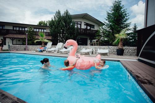 a woman and two children playing in a swimming pool at Penzion Panorama in Liptovský Mikuláš