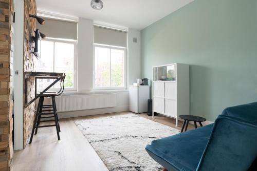 a living room with a blue couch and a chair at Happy Day´s in Amsterdam