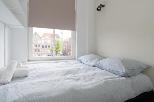 a white bed in a room with a window at Happy Day´s in Amsterdam